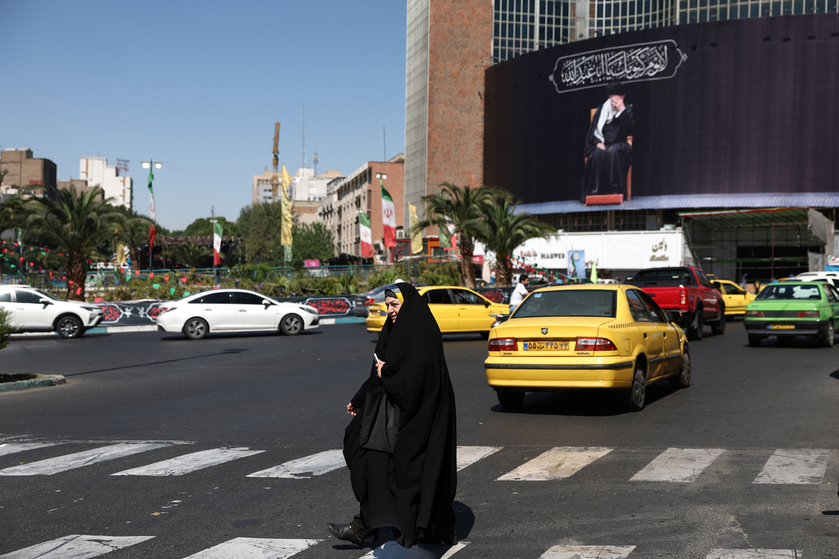 A woman walks past a billboard with a picture of the late Iran's Supreme Leader Ayatollah Ali Khamenei, after U.S. and Iranian officials said they had reached a deal to end their war and reopen the Strait of Hormuz, in Tehran, Iran, June 15, 2026. Majid Asgaripour/WANA (West Asia News Agency) via REUTERS