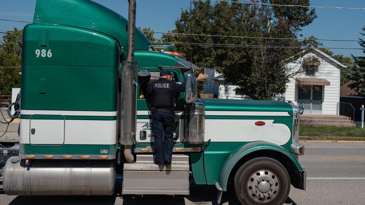 NYTSELECTS -- Joe Baez, a truck enforcement officer in Manhattan, Ill., pulls over a semi for being too long in a length-restricted stretch of road on Sept. 15, 2025. 25 years ago, the far outskirts of the Chicago suburbs were mostly farmland. Today, warehouse complexes dominate. With them, the roads have become increasingly dangerous.  (Jamie Kelter Davis/The New York Times)..