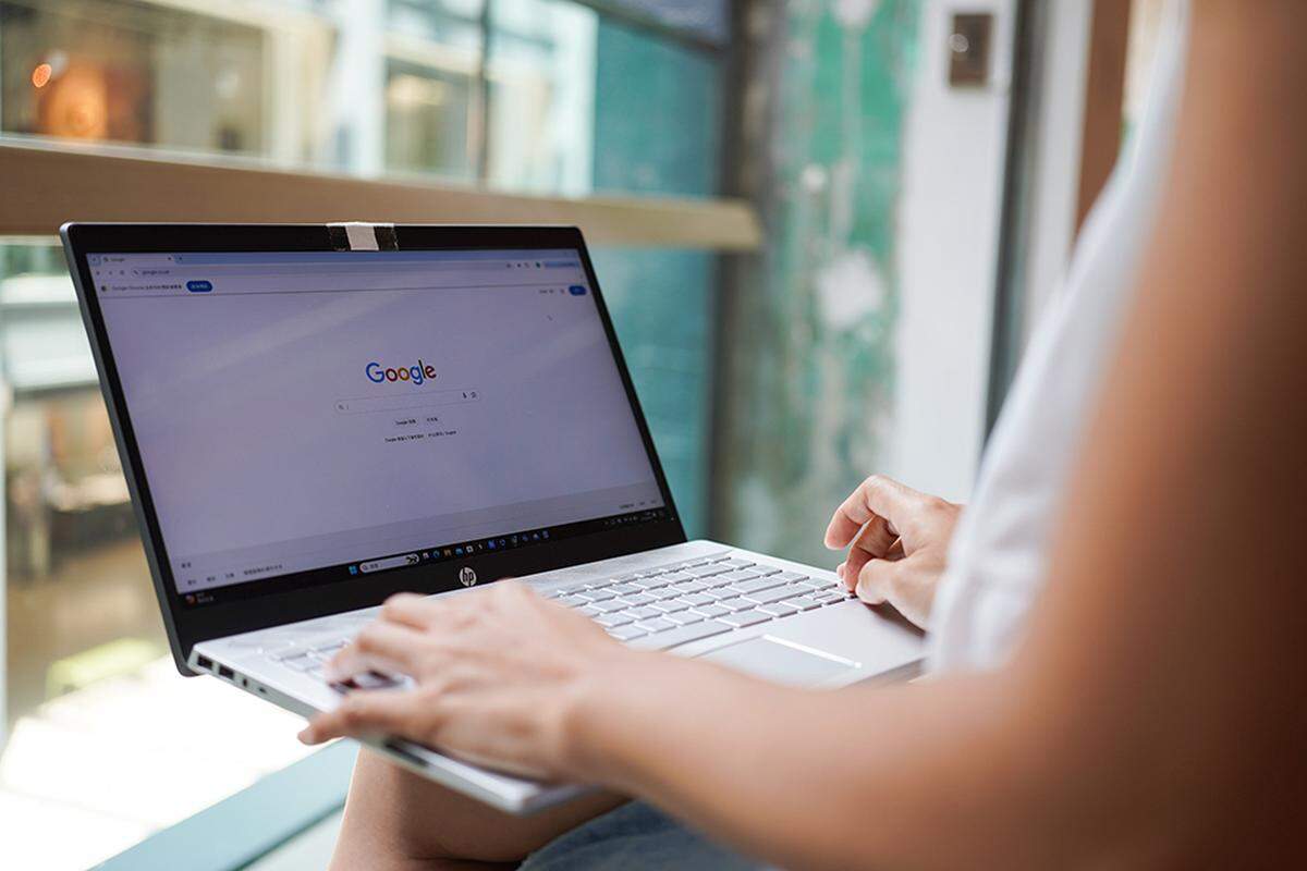 A woman browses the Google website on her laptop.