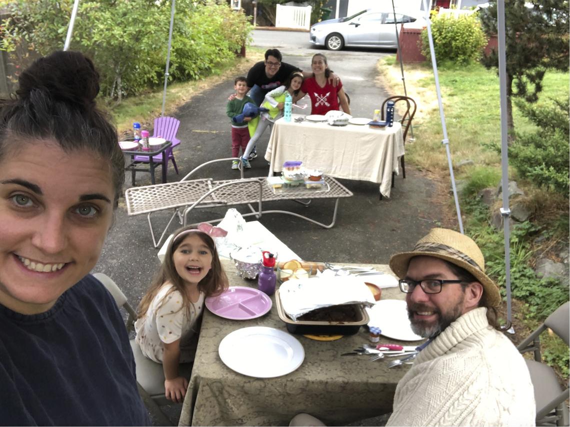 With COVID-19 making indoor dinners with friends a potential health risk, Jennifer Fliss, front left, held a socially-distanced Rosh Hashanah supper with neighbors in her Seattle driveway this year, as seen in this photo from Sept. 19, 2020. She’ll likely do the same for Thanksgiving this year.