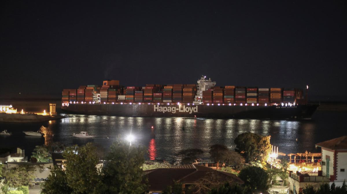 Un carguero pasa por la localidad de Suez, Egipto, tras la reapertura del Canal de Suez, que estuvo casi una semana bloqueado por un buque que se había quedado atravesado. (AP Foto/Mohamed Elshahed)