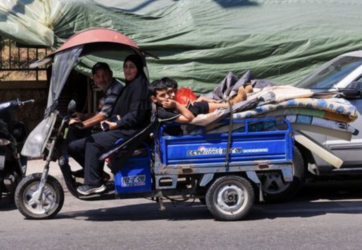 A family loads their belongings into a small cart as they prepare to return home following an interim deal between the U.S. and Iran, after living in temporary tents in Beirut, Lebanon, June 24, 2026. REUTERS/Mohamed Azakir