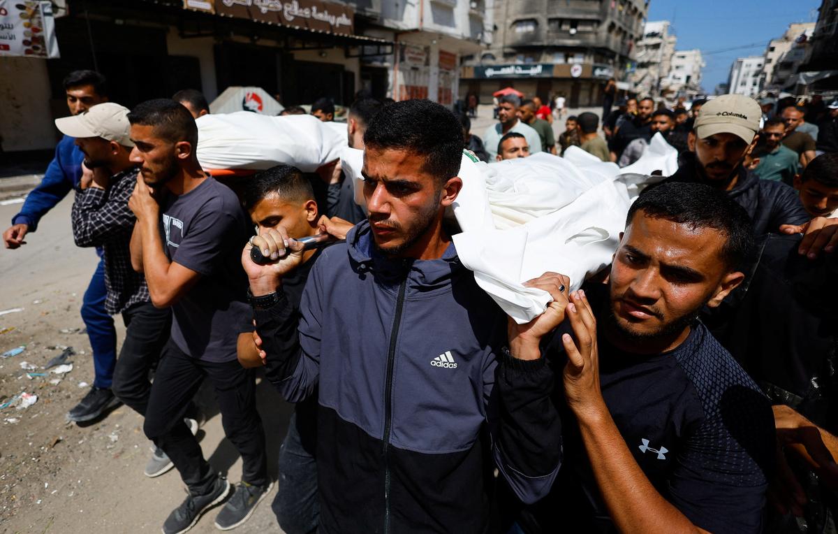 People carry bodies identified by mourners as Hamas' military wing commander Mohammad Odeh, who was killed in an Israeli strike on Tuesday, and his wife and children, during a funeral, in Gaza City, May 27, 2026. REUTERS/Mahmoud Issa