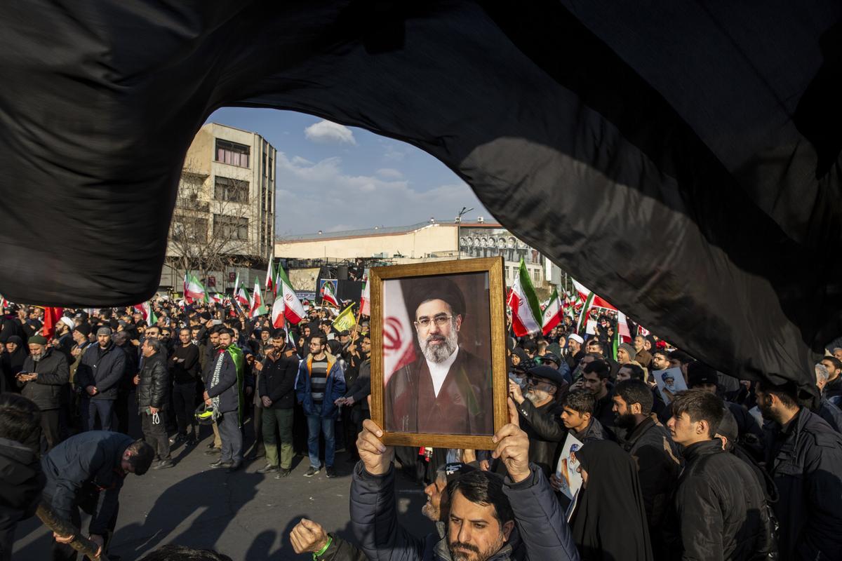 FILE -- A portrait of Mojtaba Khamenei, the son of the recently killed supreme leader Ayatollah Ali Khamenei, as a crowd celebrates his appointment as his father's successor at Enghelab Square in Tehran, Iran, on Monday, March 9, 2026. The killing of Ayatollah Ali Khamenei has ushered in a new form of collective leadership, with more power for the generals of the Revolutionary Guard. (Arash Khamooshi/The New York Times)