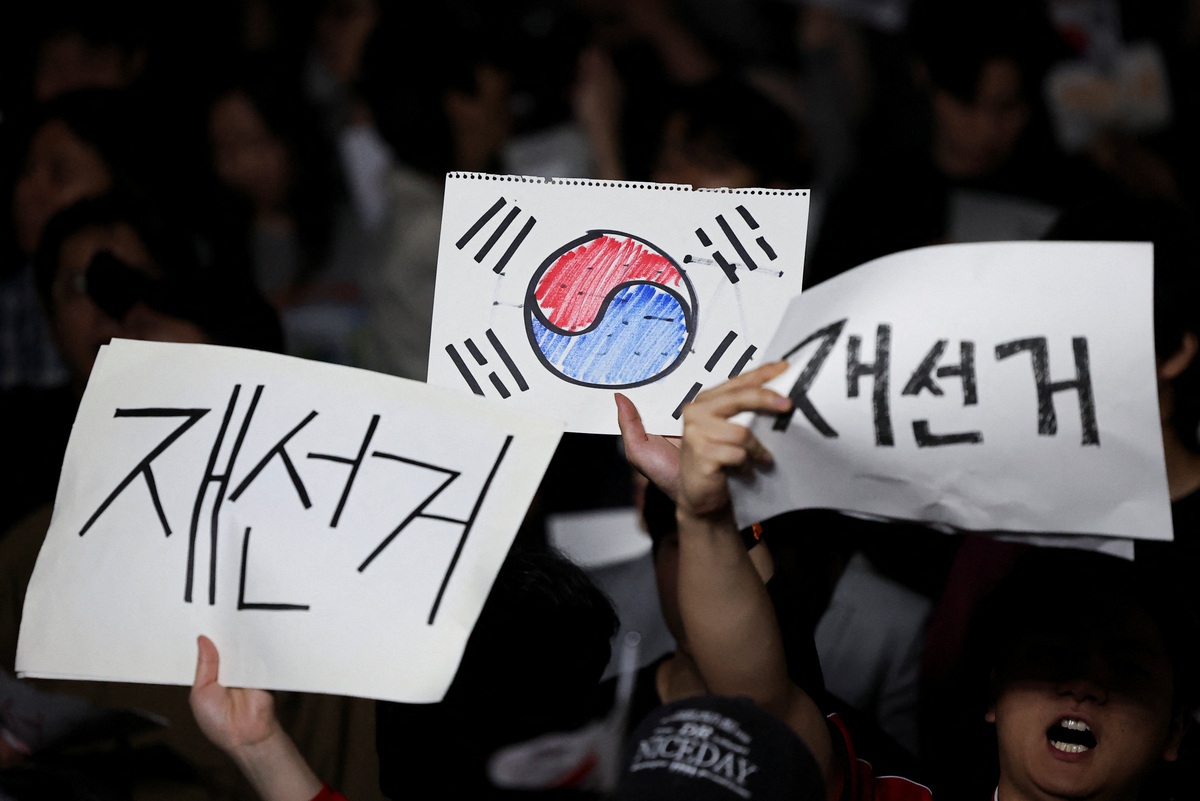 Demonstrators hold signs reading, "Reelection", as people surround a vote-counting centre to protest a controversy over a shortage of ballot papers that disrupted voting in the local election and to call for a rerun of the election, in Seoul, South Korea, June 6, 2026. REUTERS/Kim Hong-Ji