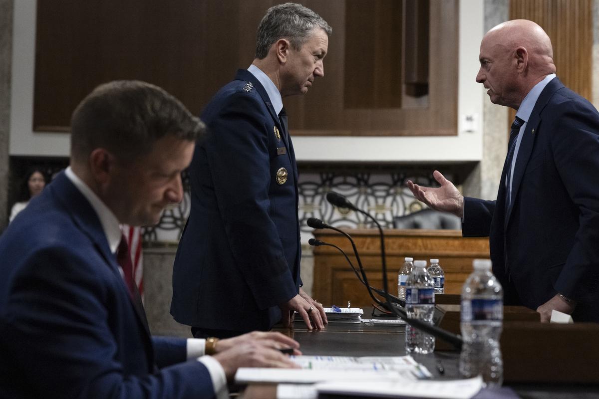 Sen. Mark Kelly (D-Ariz.) speaks to Gen. Dan Caine, chairman of the Joint Chiefs of Staff, ahead of a Senate Armed Services Committee hearing on the Department of Defense's budget request on Capitol Hill in Washington, on Thursday, April 30, 2026. (Anna Rose Layden/The New York Times)