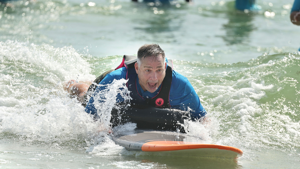 Army veteran Jeff Palenske enjoys riding a wave at New Smyrna Beach on Saturday, June 13, 2026. The group Oceans of Hope brought dozens of injured veterans to surf the waves with the help of nearly 100 volunteers. (Stephen M. Dowell/Orlando Sentinel)