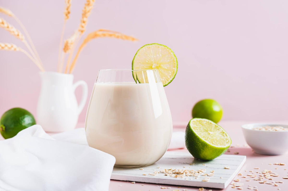  Homemade oatzempic drink of oat milk and lime in a glass on the table.