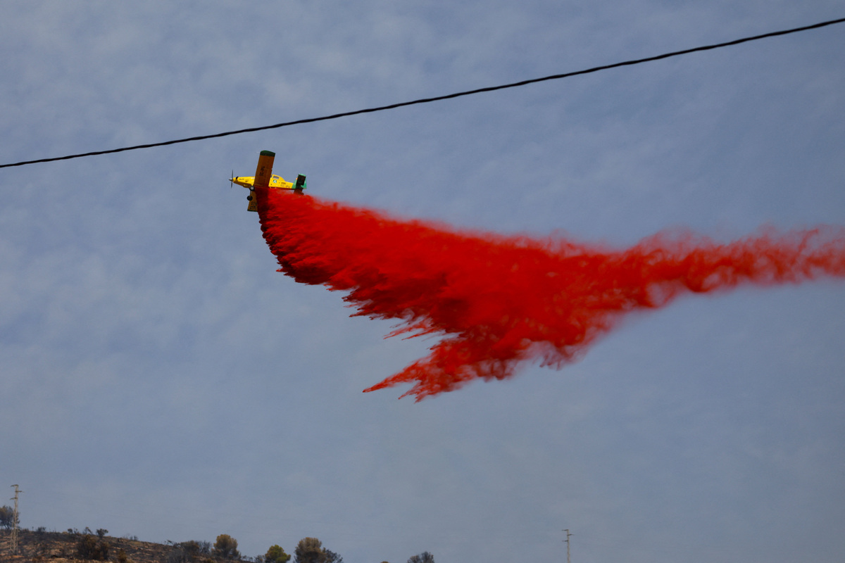 An aircraft drops fire retardant above wildfires affecting Almeria province, in Los Gallardos, Spain, July 11, 2026. REUTERS/Jon Nazca