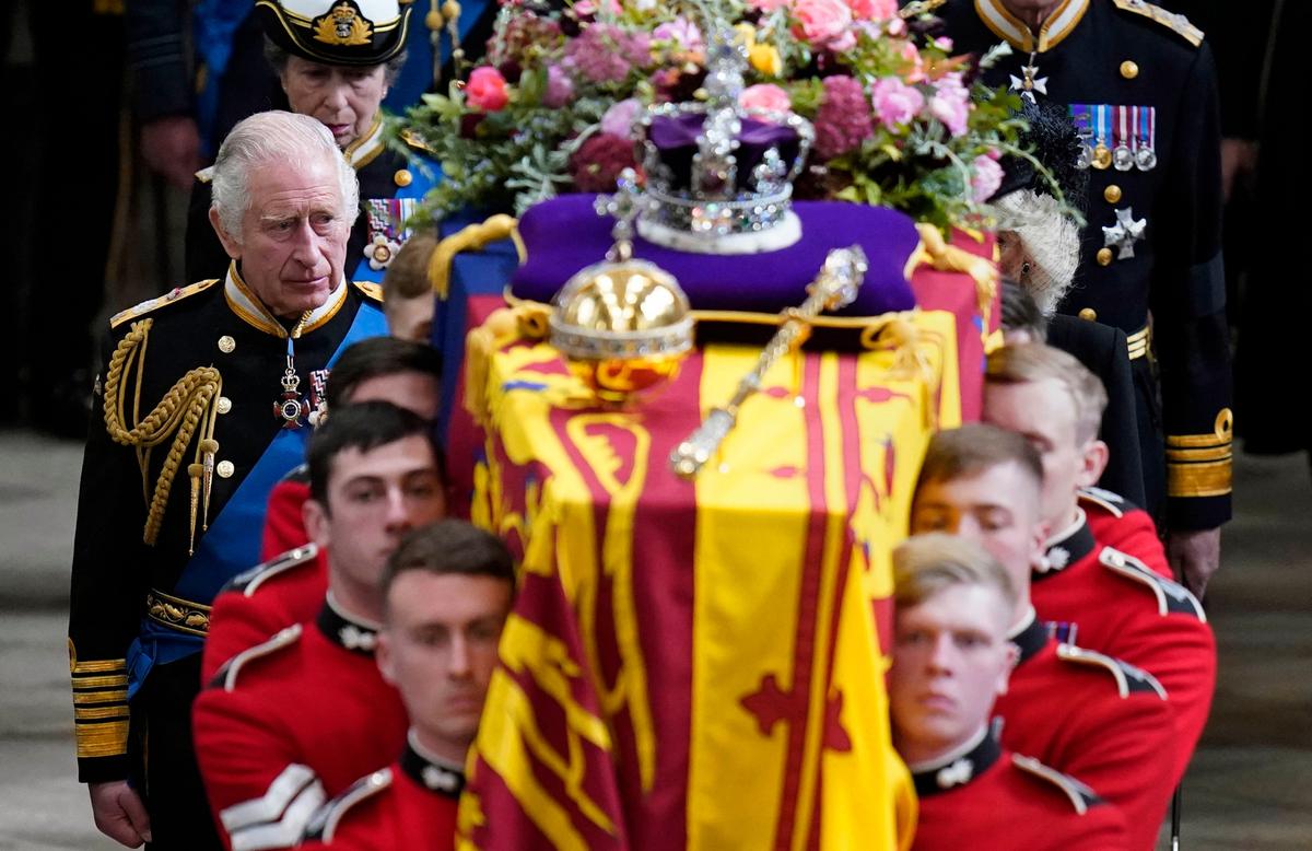 El rey Carlos III y los miembros de la familia real siguen detrás del ataúd de la reina Isabel II, envuelto en el estandarte real con la corona del Estado imperial y el orbe y el cetro del soberano, mientras se lleva a cabo en la Abadía de Westminster después de su funeral de Estado, en Londres, lunes 19 de septiembre de 2022.