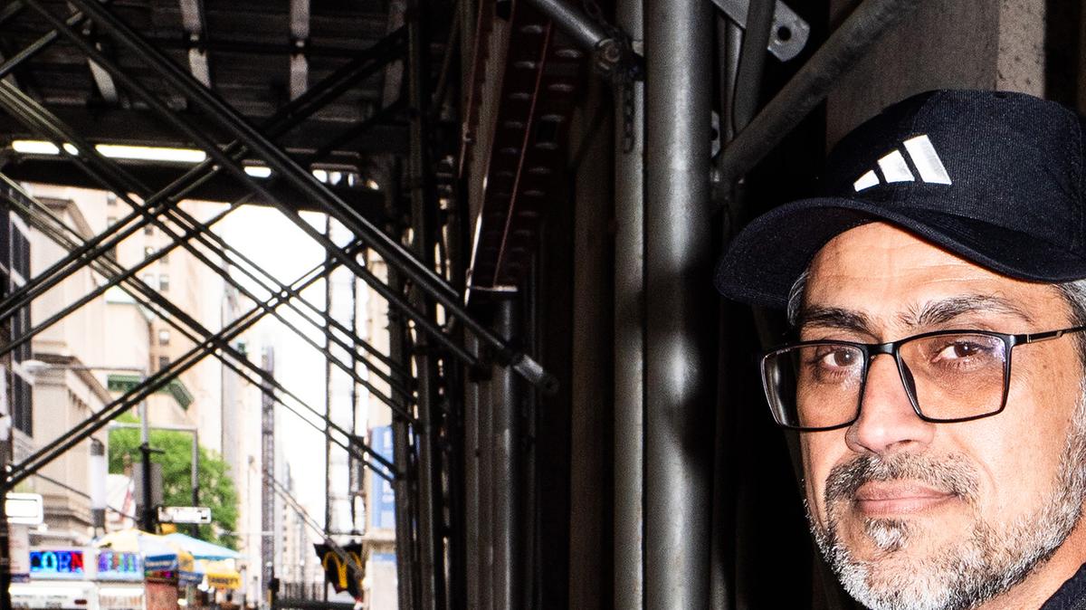 Choudhary Muhammad Kamran, 47, an entrepreneur with businesses in Dubai, New York, Singapore and Pakistan, holds two phones and a battery bank in New York, May 11, 2026. He has used at least two cellphones since 2000. (Graham Dickie/The New York Times)