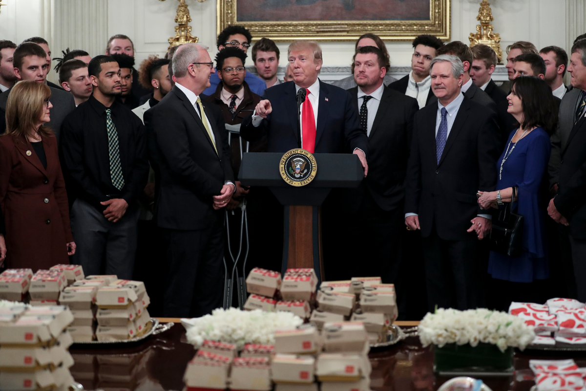  President Donald Trump speaks behind a table full of McDonald’s hamburgers, Chick fil-a sandwiches and other fast food as he welcomes the 2018 Football Division I FCS champs North Dakota State Bison in the Diplomatic Room of the White House on March 4, 2019 in Washington, D.C. 
