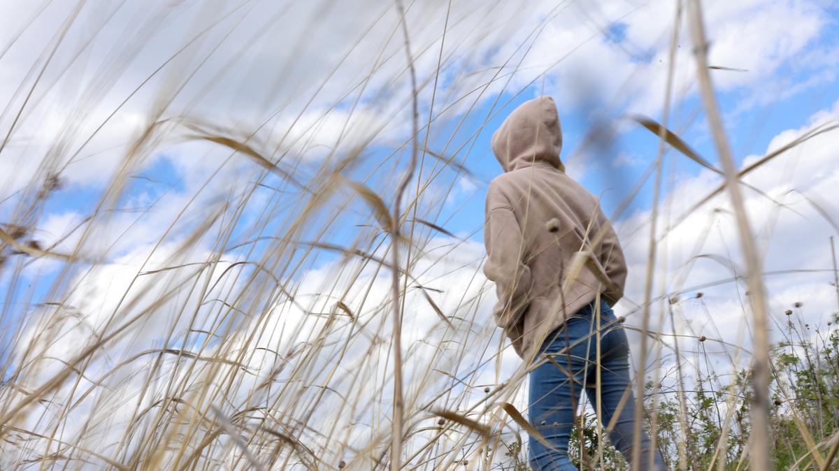 A woman stands in a Cook County forest preserve on May 6, 2026, where she likes to walk to calm her mind. She said she was sexually assaulted in 2024 in her apartment at Niche 905 by a building’s security guard. (Stacey Wescott/Chicago Tribune)