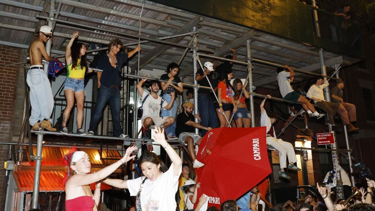 New York Knicks fans climb scaffolding while celebrating on St. Marks Place after the Knicks victory in game five of the NBA Finals in San Antonio in the early morning hours of Sunday in New York City. Photo by John Angelillo/UPI