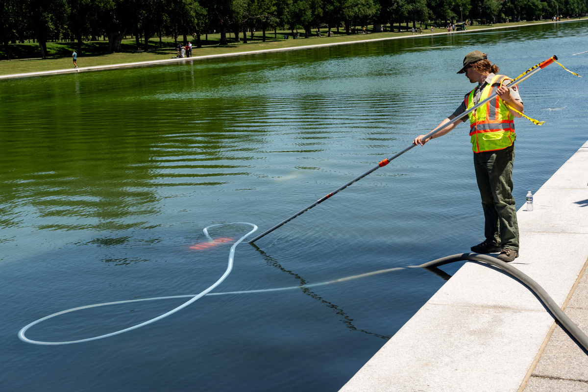 A U.S. National Park Service worker cleans algae from the Lincoln Memorial Reflecting Pool, after recent renovations following a directive from U.S. President Donald Trump to paint it blue ahead of the 250th anniversary of U.S. Independence, in Washington, D.C., U.S., June 16, 2026. REUTERS/Eric Lee