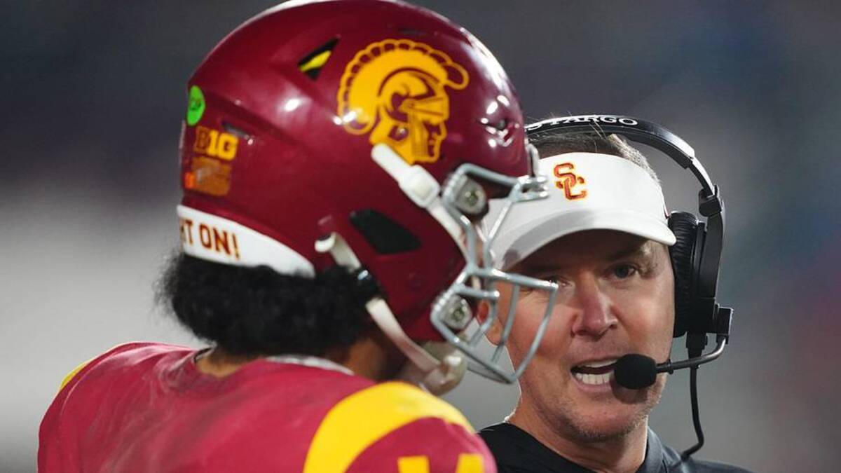  Nov 29, 2025; Los Angeles, California, USA; Southern California Trojans head coach Lincoln Riley (right) talks with quarterback Jayden Maiava (14) in the second half against the UCLA Bruins at United Airlines Field at Los Angeles Memorial Coliseum. Mandatory Credit: Kirby Lee-Imagn Images | Kirby Lee-Imagn Images 