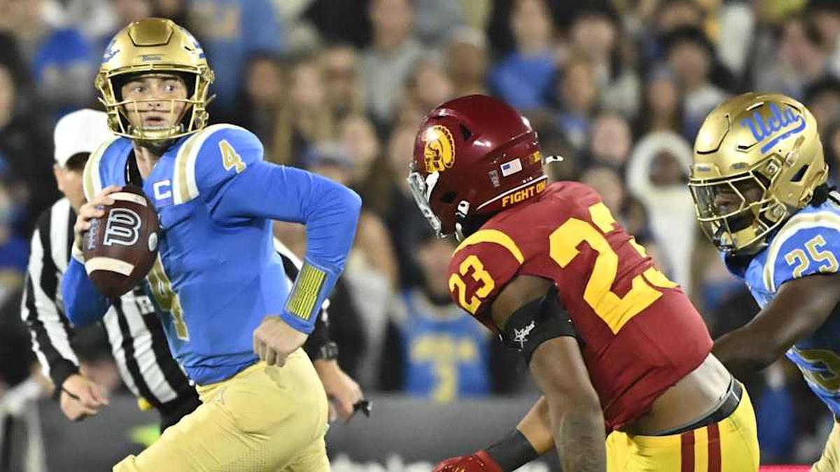  Nov 23, 2024; Pasadena, California, USA; UCLA Bruins quarterback Ethan Garbers (4) scrambles out of the pocket chased by USC Trojans linebacker Desman Stephens II (23) during the first quarter at Rose Bowl. Mandatory Credit: Robert Hanashiro-Imagn Images | Robert Hanashiro-Imagn Images 