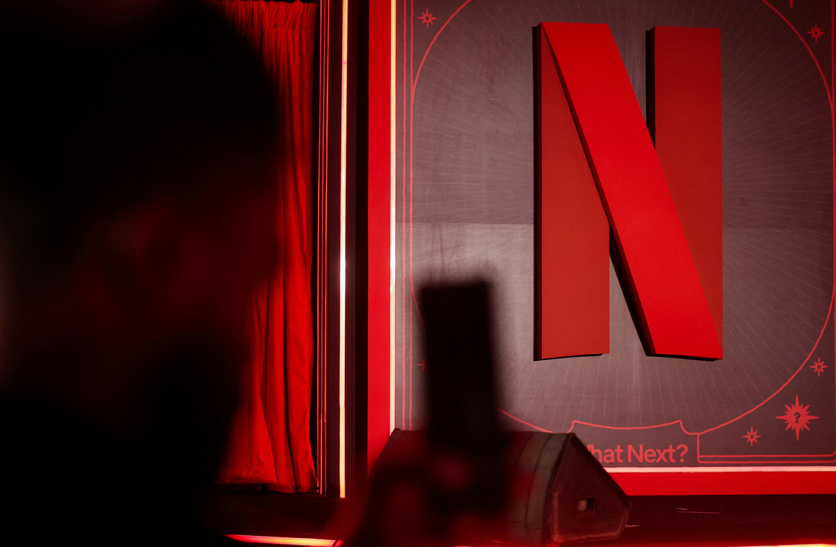 A man takes a photograph next to a Netflix logo during an event in Mumbai, India, February 3, 2026. REUTERS/Francis Mascarenhas