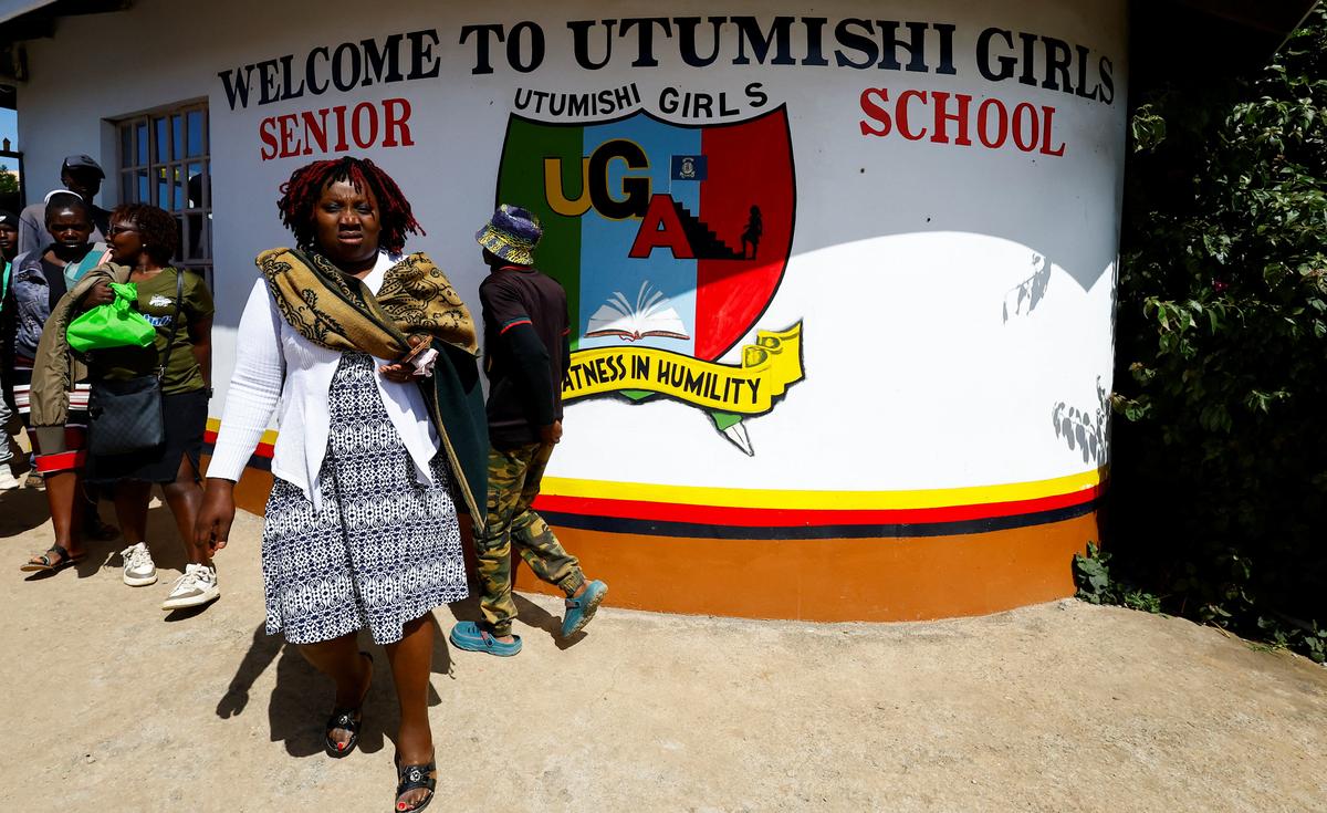 Parents and residents walk at the main entrance of Utumishi Girls' Academy Senior School following an overnight fire in a dormitory at the facility in Gilgil, Nakuru county, Kenya May 28, 2026. REUTERS/Thomas Mukoya
