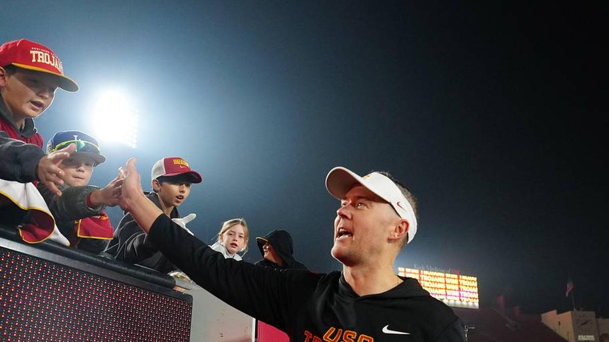  Nov 29, 2025; Los Angeles, California, USA; Southern California Trojans head coach Lincoln Riley celebrates with fans after the game against the UCLA Bruins at United Airlines Field at Los Angeles Memorial Coliseum. Mandatory Credit: Kirby Lee-Imagn Images | Kirby Lee-Imagn Images 