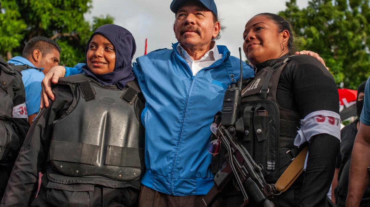 El gobernante nicaragüense Daniel Ortega posa con dos agentes policiales el 13 de julio de 2018 en Masaya, Nicaragua. El régimen de Ortega ha emprendido una campaña represiva contra varios candidatos presidenciales y los ha puesto en prisión.
