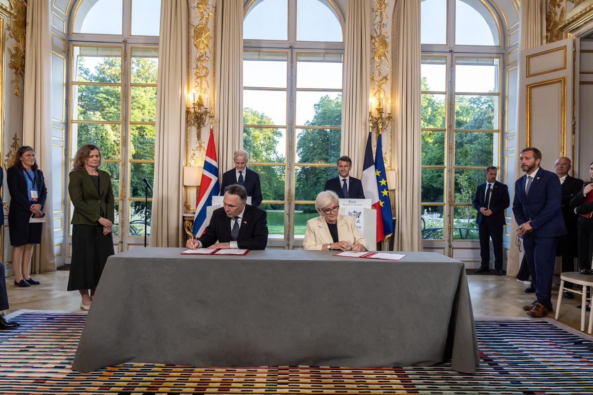 France's President Emmanuel Macron and Norway's Prime Minister Jonas Gahr Stoere look as Norwegian Defense Minister Tore Sandvik and French Defence and Veterans Minister Catherine Vautrin sign an agreement prior to a working dinner at the Elysee Palace in Paris, France, 27 May 2026.  CHRISTOPHE PETIT TESSON/Pool via REUTERS