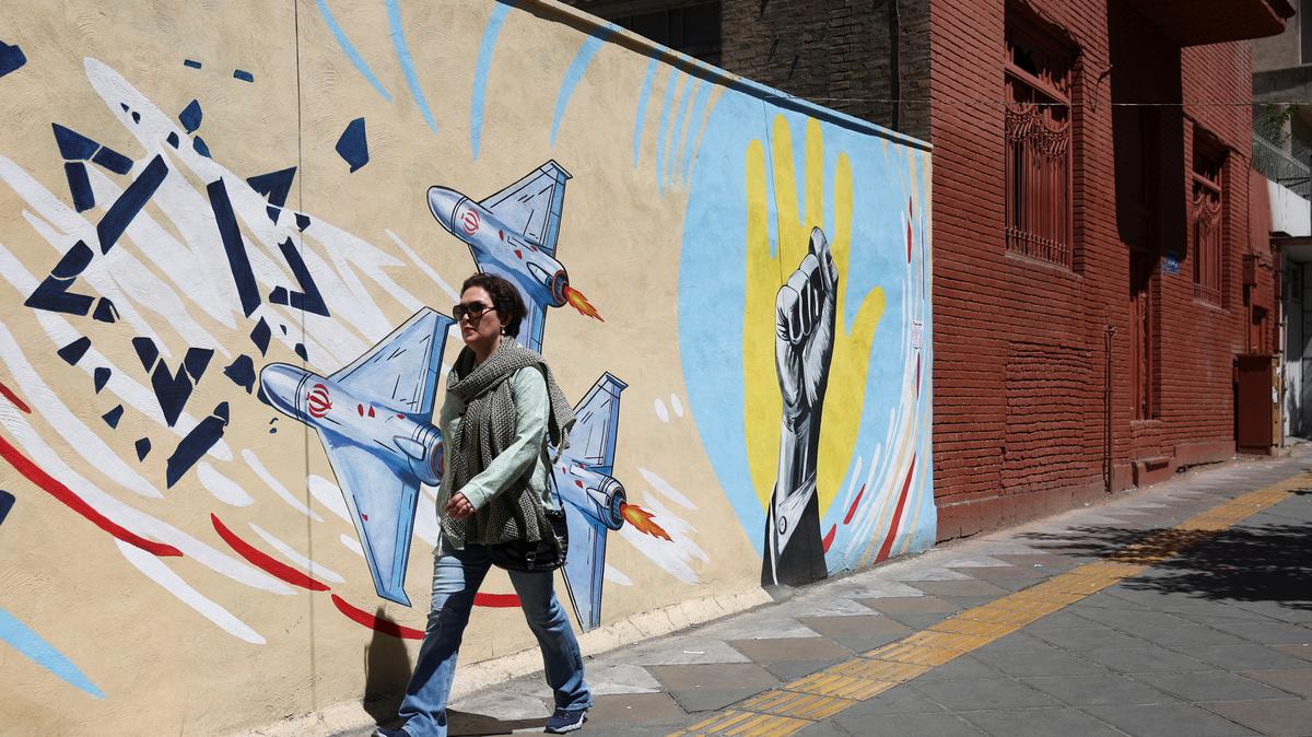 An Iranian woman walks next to an anti-Israeli mural on a street in Tehran, Iran, May 26, 2026. Majid Asgaripour/WANA (West Asia News Agency) via REUTERS