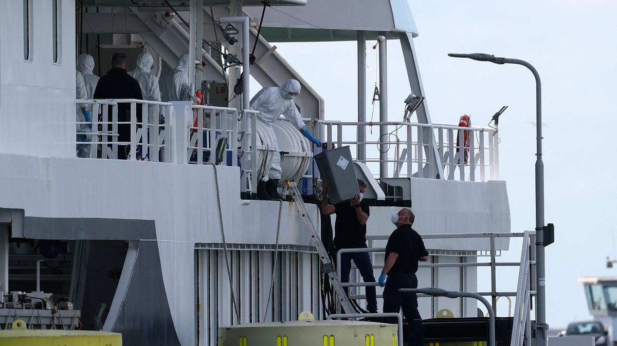 People wearing protective equipment interact with the crew of the cruise ship MV Hondius, which was affected by a hantavirus outbreak, after the ship arrived at the Port of Rotterdam, where Dutch authorities are preparing quarantine arrangements, in Rotterdam, Netherlands, May 18, 2026. REUTERS/Piroschka van de Wouw