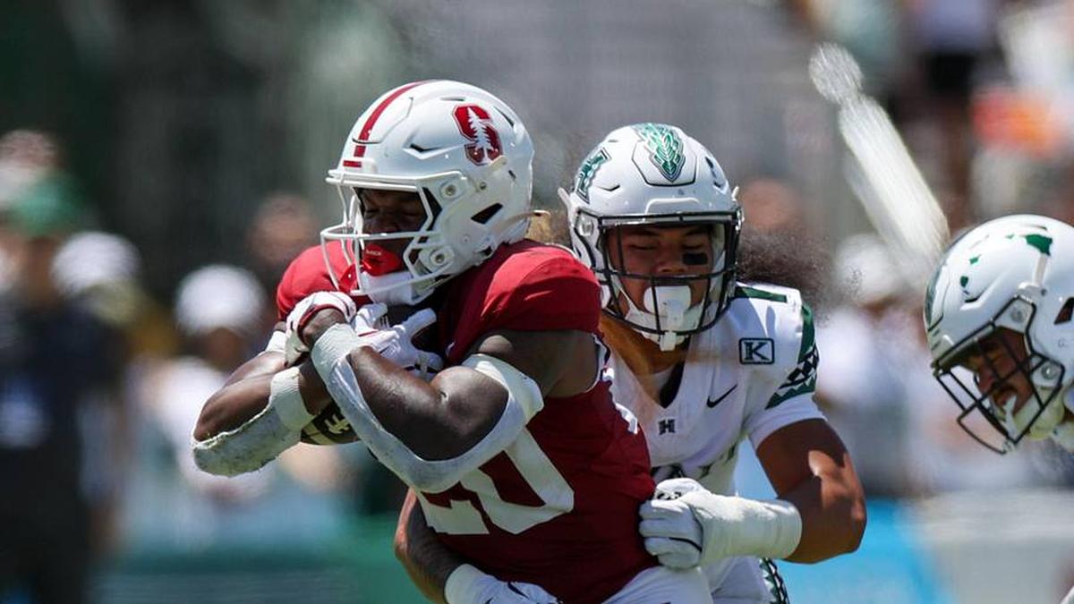  Aug 23, 2025; Honolulu, Hawaii, USA; Hawaii Rainbow Warriors defensive back Peter Manuma (1) tries to pull down Stanford Cardinal running back Micah Ford (20) during the first half of an NCAA college football game at Clarence T.C. Ching Athletics Complex. Mandatory Credit: Marco Garcia-Imagn Images | Marco Garcia-Imagn Images 