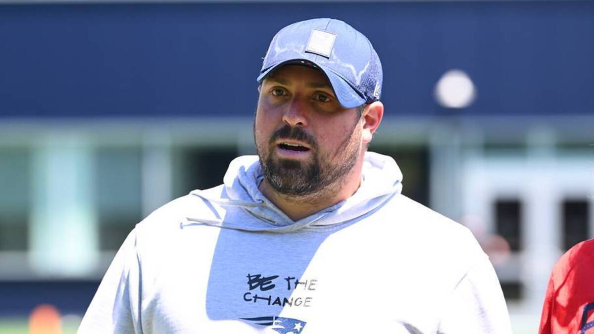  Jun 9, 2026; Foxborough, MA, USA; New England Patriots defensive coordinator Zak Kuhr walks to the podium for a press conference before minicamp at Gillette Stadium. Mandatory Credit: Eric Canha-Imagn Images | IMAGN IMAGES via Reuters Connect 