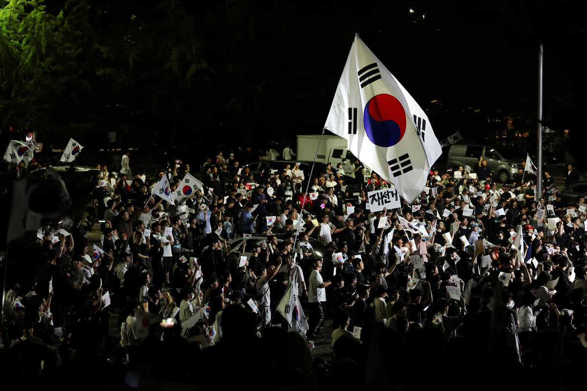 A large South Korean flags flies over protesters as they surround a vote-counting centre to protest a controversy over a shortage of ballot papers that disrupted voting in the local election and to call for a rerun of the election, in Seoul, South Korea, June 6, 2026. REUTERS/Kim Hong-Ji