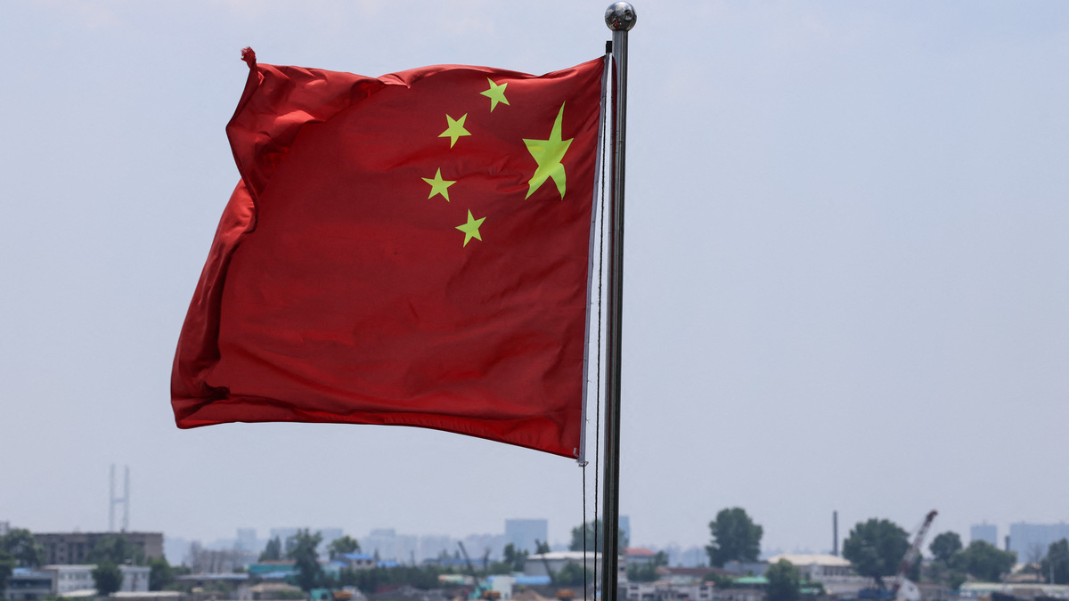 The Chinese national flag flies in the wind over the Yalu River, with buildings of the North Korean city of Sinuiju behind, on the bank across, in Dandong, Liaoning province, China, June 8, 2026. REUTERS/Maxim Shemetov