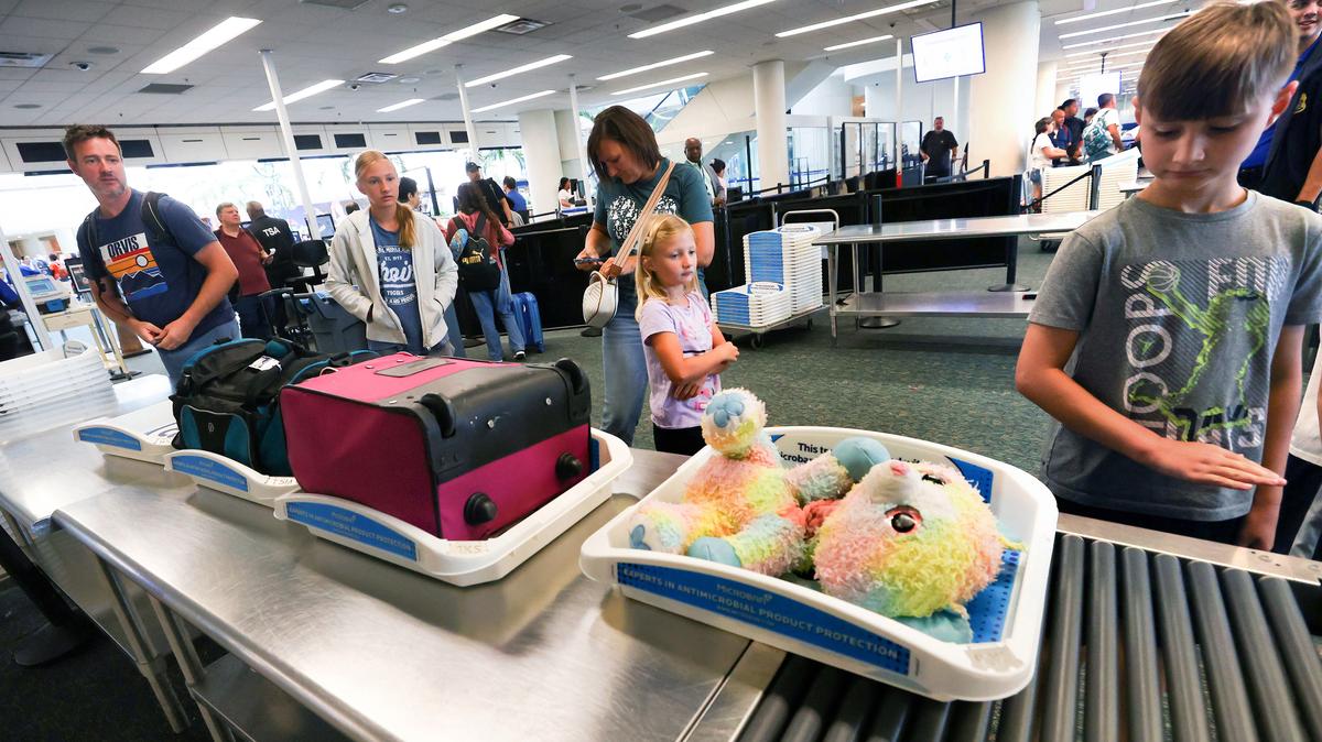 Young passengers go through a new family-exclusive TSA lane at Orlando International Airport, Tuesday, Aug. 5, 2025. The lane provides dedicated screening access for families traveling with children under age 12. (Joe Burbank/Orlando Sentinel)