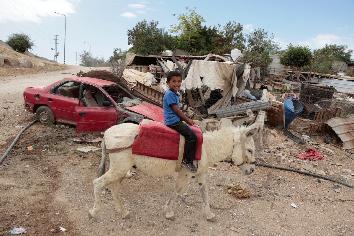 A Palestinian Bedouin child sits on a donkey in al-Khan al-Ahmar near Jericho, in the Israeli-occupied West Bank, May 20, 2026. REUTERS/Mohammed Torokman