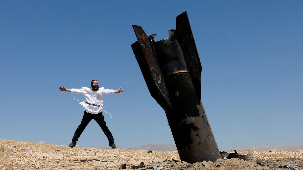 An Israeli ultra-Orthodox Jewish man reacts near a part of a missile protruding from the ground, following strikes from Iran, in the central Israeli-occupied West Bank, June 8, 2026. REUTERS/Ammar Awad