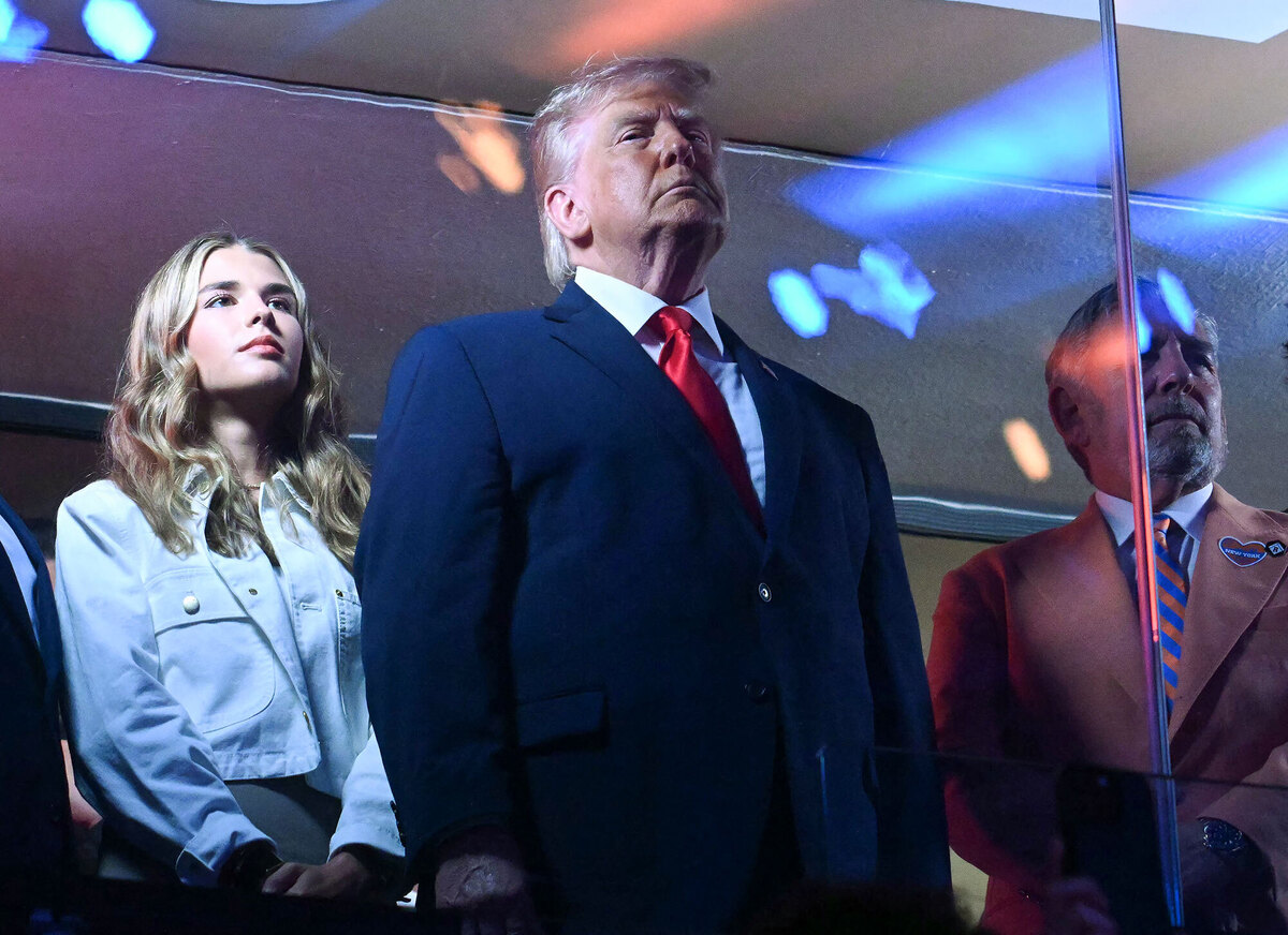  Kai Trump (L), US President Donald Trump (C) and Knicks owner James Dolan stand during the National Anthem as they attend Game Three of the NBA Finals between the San Antonio Spurs and the New York Knicks at Madison Square Garden in New York on June 8, 2026.SAUL LOEB / AFP via Getty Images 