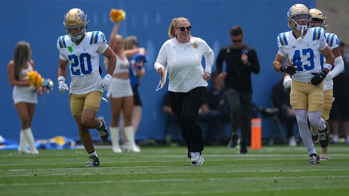  May 2, 2026; Pasadena, CA, USA; UCLA Bruins women's basketball coach Cori Close enters the field with receiver Shane Rosenthal (20) and defensive back Brett Barry (43) during the spring game at Rose Bowl. Mandatory Credit: Kirby Lee-Imagn Images | Kirby Lee-Imagn Images 