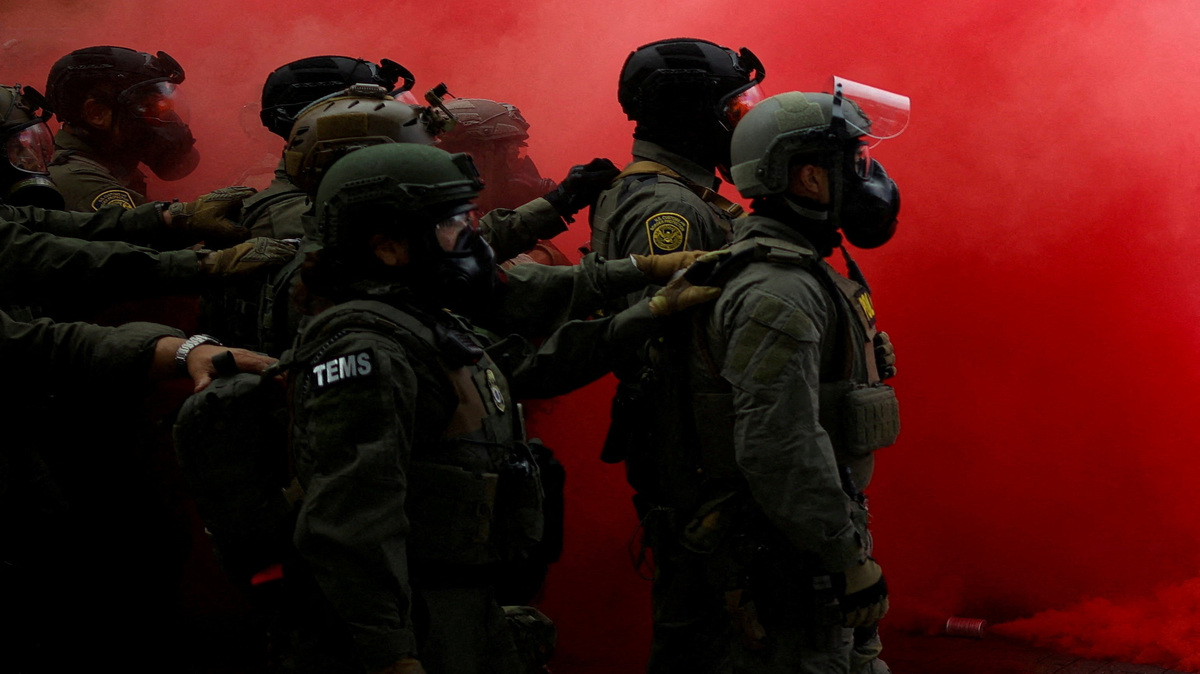Law enforcement officers stand amid smoke from a smoke grenade released to disperse demonstrators in front of the U.S. Immigration and Customs Enforcement (ICE) headquarters in Portland, Oregon, U.S., October 4, 2025.  REUTERS/Carlos Barria   TPX IMAGES OF THE DAY   Pulitzer Prize Finalist for Breaking News Photography