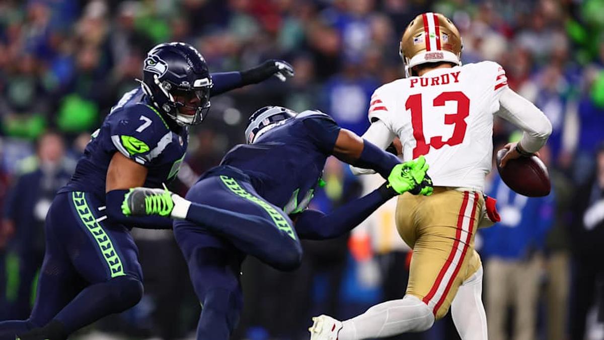  Jan 17, 2026; Seattle, WA, USA; San Francisco 49ers quarterback Brock Purdy (13) is pressured by the Seattle Seahawks defense during the second half in an NFC Divisional Round game at Lumen Field. Mandatory Credit: Kevin Ng-Imagn Images | Kevin Ng-Imagn Images 