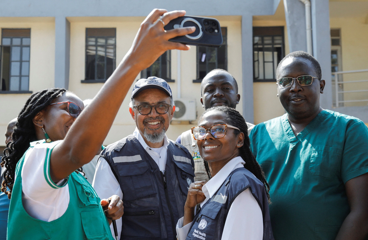 Ugandan medical staff take a selfie with Director-General of the World Health Organisation (WHO) Tedros Adhanom Ghebreyesus, during his visit at the Mulago National Referral Hospital Isolation Unit, as aid agencies intensify efforts to contain a new Ebola outbreak involving the Bundibugyo Virus, in Mulago suburb, of Kampala, Uganda June 8, 2026. REUTERS/ Abubaker Lubowa