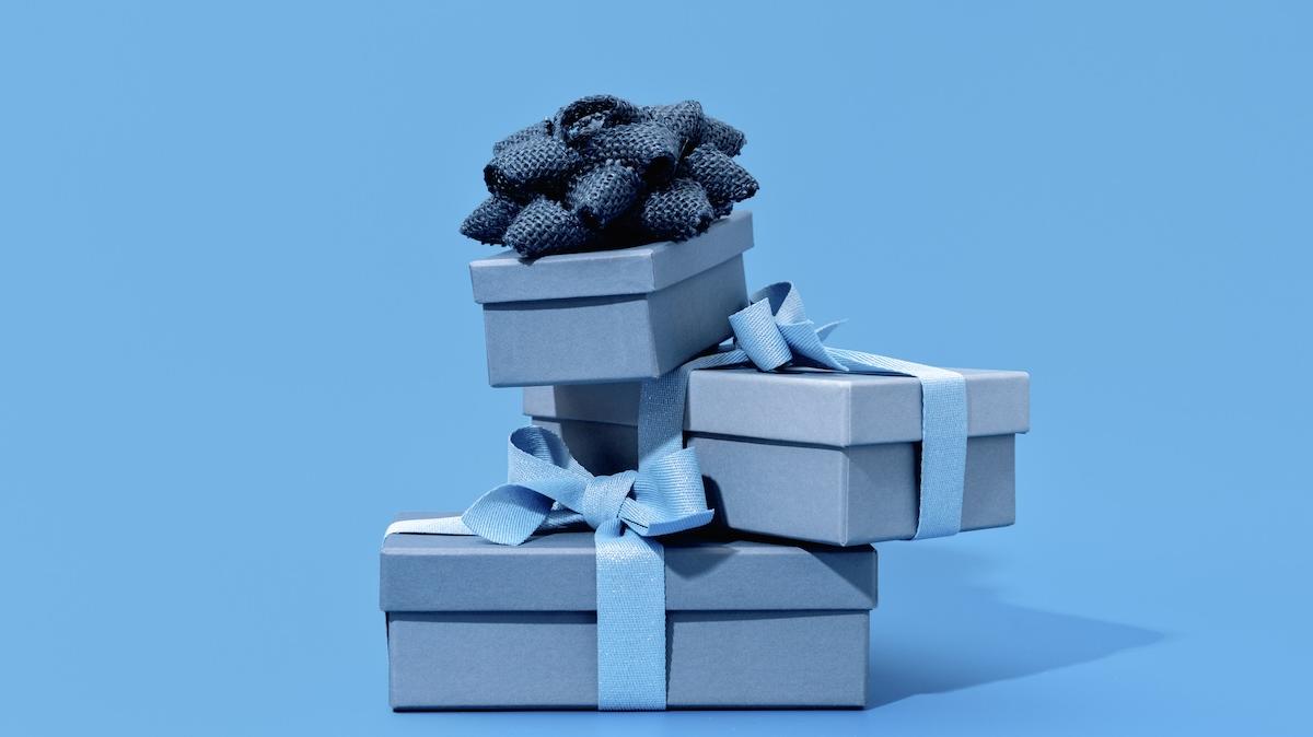 Stack of Three Elegant Blue gift boxes with bow ribbon on monochrome blue background. Luxury gift for man or Fathers Day. Side view