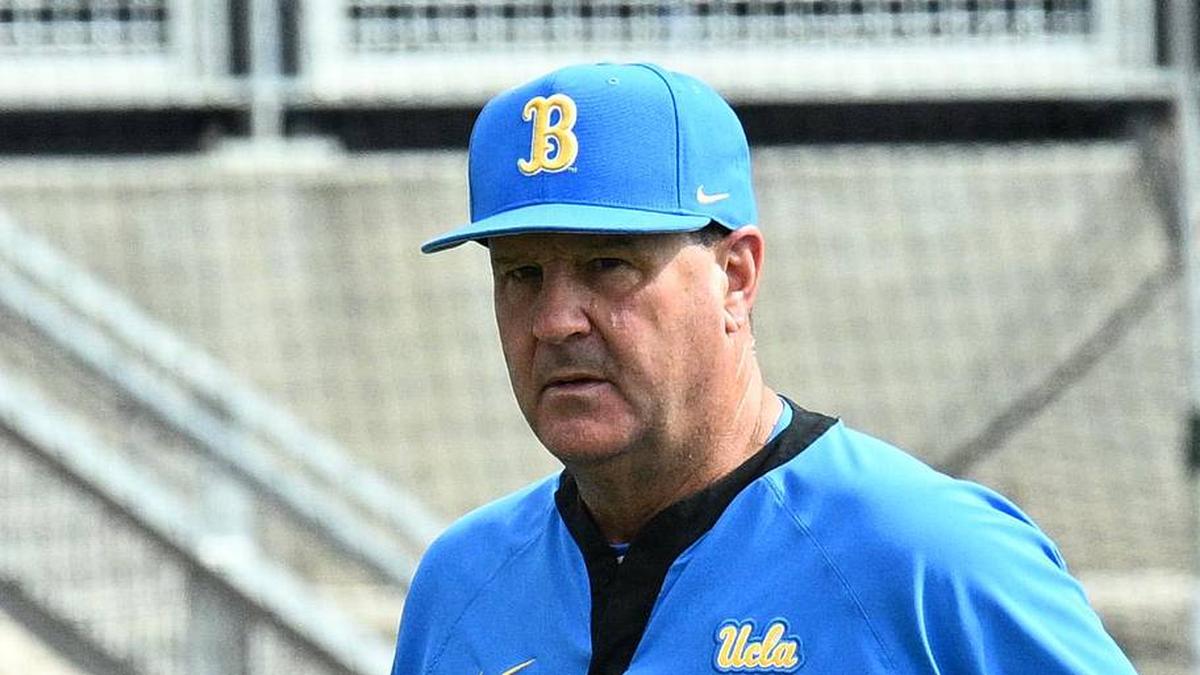  Jun 17, 2025; Omaha, Neb, USA; UCLA Bruins head coach John Savage (22) walks to the dugout before the restart of the game against the LSU Tigers at Charles Schwab Field. Mandatory Credit: Steven Branscombe-Imagn Images | Steven Branscombe-Imagn Images 