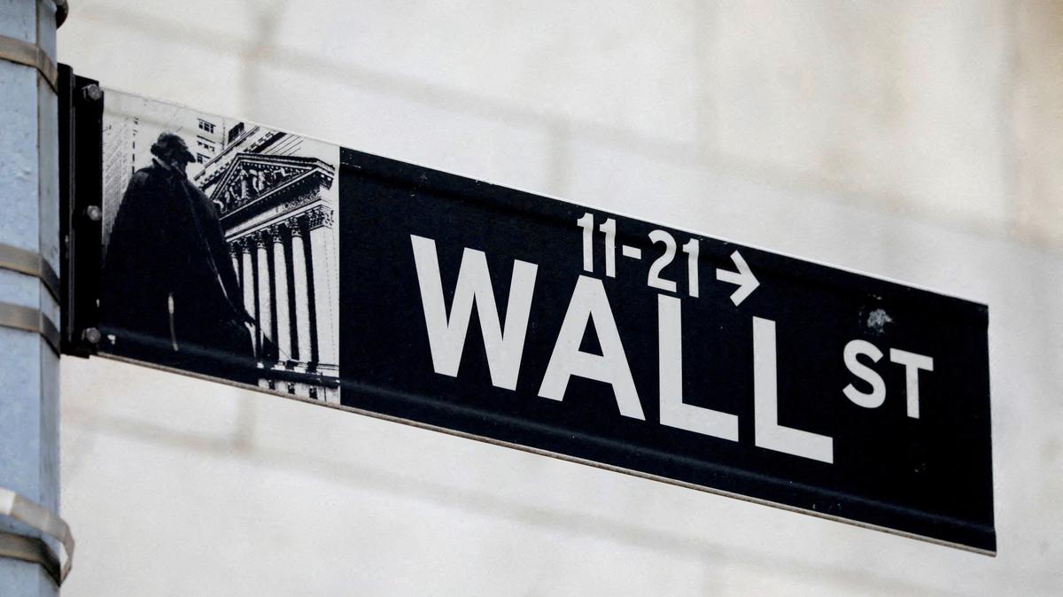 FILE PHOTO: FILE PHOTO: A street sign for Wall Street is seen outside of the New York Stock Exchange (NYSE) in New York City, U.S., June 28, 2021. REUTERS/Andrew Kelly/File Photo
