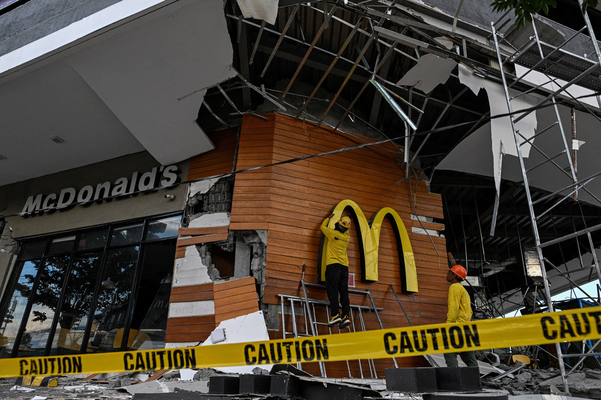 Workers remove a McDonald's logo a day after the magnitude 7.8 quake in General Santos, southern Philippines, June 9, 2026. REUTERS/Noel Celis