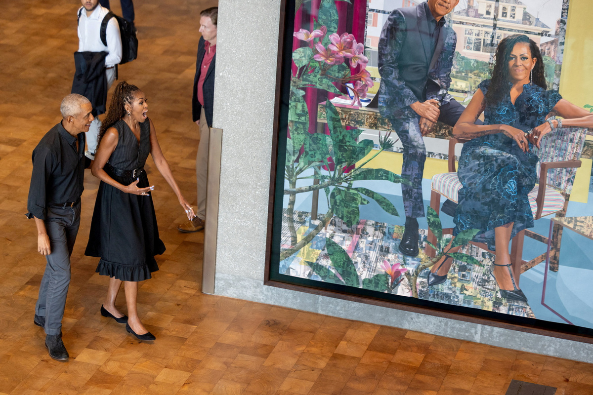 Former U.S. President Barack Obama and former U.S. first lady Michelle Obama react next to their first commissioned portrait by Njideka Akunyili Crosby in the Hope and Change Lobby of the Obama Presidential Center Museum in Chicago, Illinois, U.S., June 14, 2026. Taylor Glascock/The Obama Foundation/Handout via REUTERS