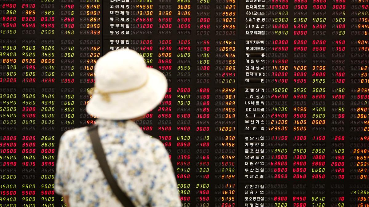 An investor looks at an electronic board showing stock price index at a stock brokerage firm in Seoul July 1, 2009. Frustrated by poor returns and high fees, South Korean retail investors are dumping equity funds and picking stocks on their own, raising the prospect of consolidation in the domestic asset management industry. Picture taken July 1, 2009. To match analysis INVESTORS/KOREA. REUTERS/Jo Yong-Hak (SOUTH KOREA BUSINESS)