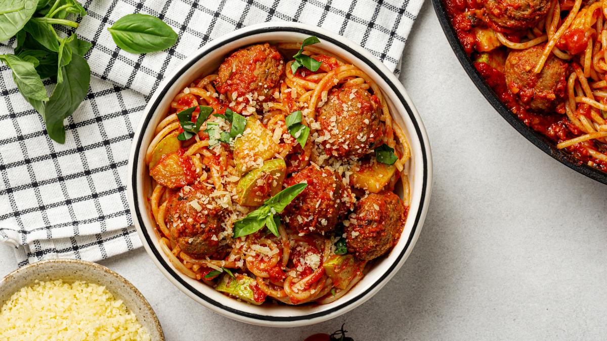 Spaghetti and meatballs with zucchini and basil. Top view.