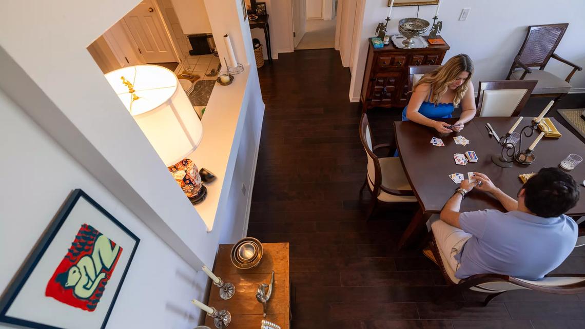 The couple play Phase 10 on the dining room table they purchased from the UCLA Thrift Shop.