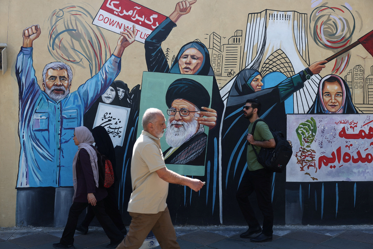 People walk on a street near a mural featuring an image of the late Supreme Leader of Iran, Ayatollah Ali Khamenei, in Tehran, Iran June 8, 2026. Majid Asgaripour/WANA (West Asia News Agency) via REUTERS