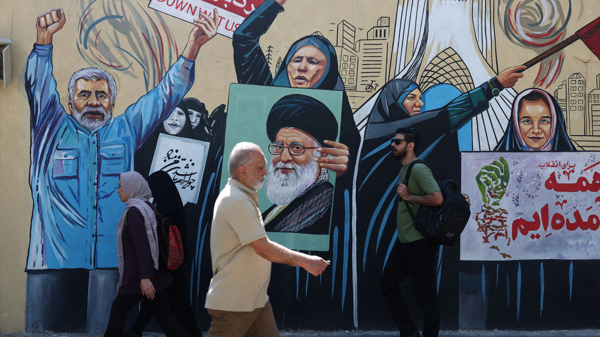 People walk on a street near a mural featuring an image of the late Supreme Leader of Iran, Ayatollah Ali Khamenei, in Tehran, Iran June 8, 2026. Majid Asgaripour/WANA (West Asia News Agency) via REUTERS